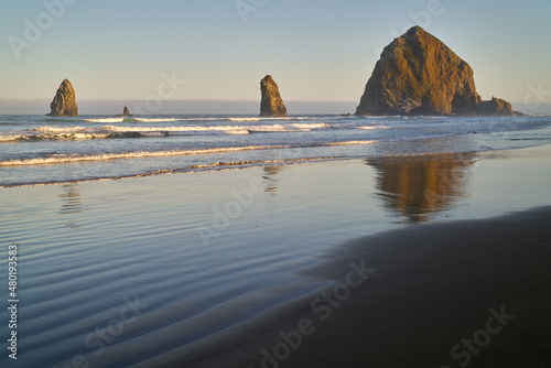 Cannon Beach Scenic Shore. Early morning at Haystack Rock in Cannon Beach, Oregon as the surf washes up onto the beach. United States. 