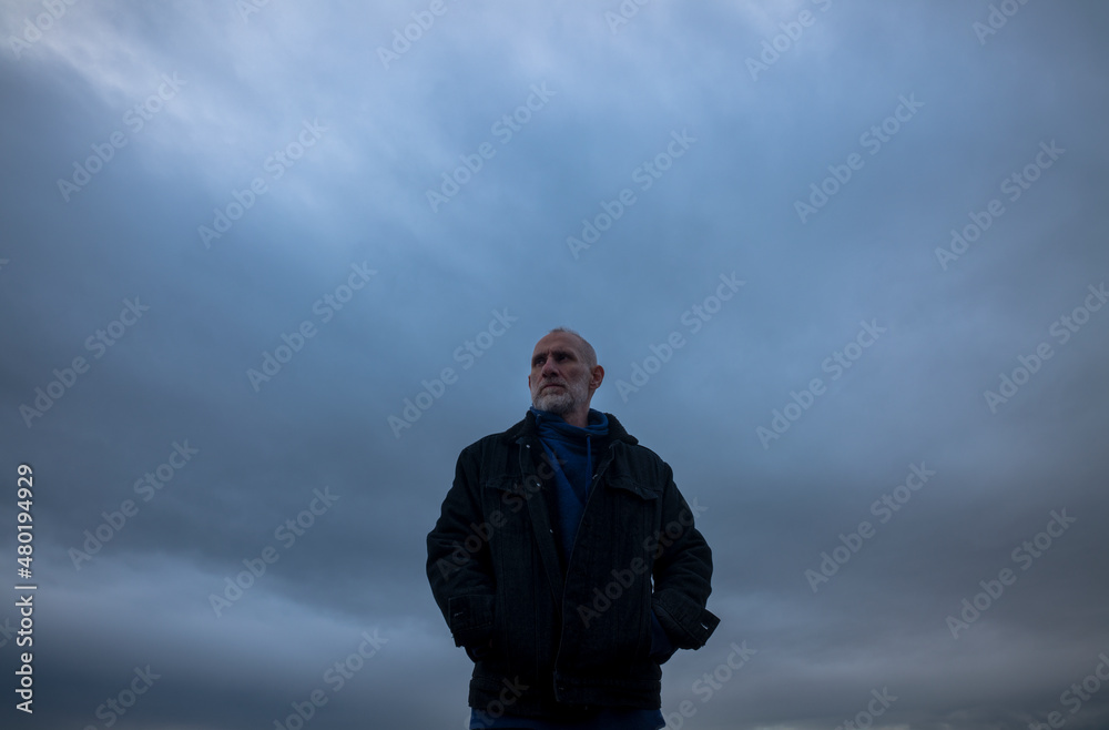 Adult man in winter clothes on beach during sunset. Almeria, Spain Adult man in winter clothes on beach during sunset. Almeria, Spain
