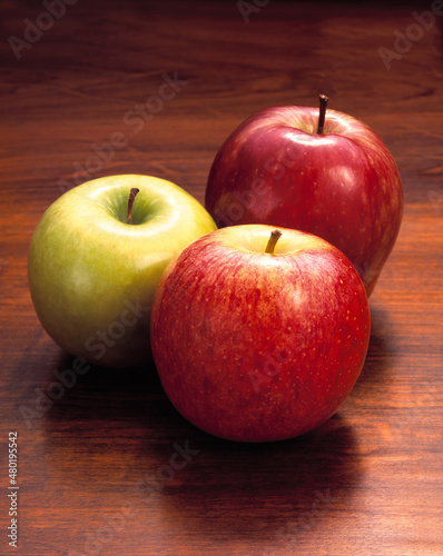 Suculentas maçãs variadas em fundo de madeira rústica