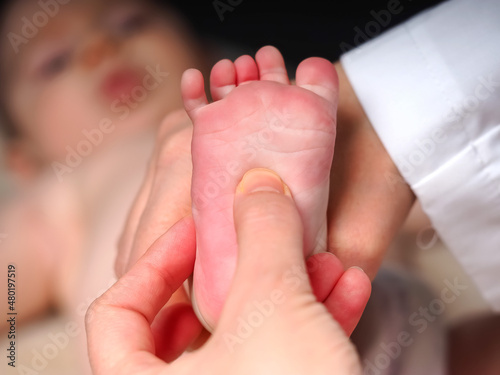 doctor checks the reflexes of a newborn baby on the sole of the foot