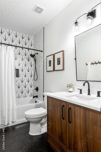 Modern bathroom white tub, walnut vanity, matte black faucets, white walls, mid century transitional style