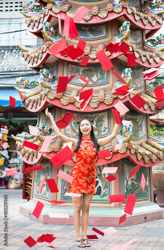 Beautiful Asian woman with red Cheongsam dress trown up many red envelope in Chinese New Year photo