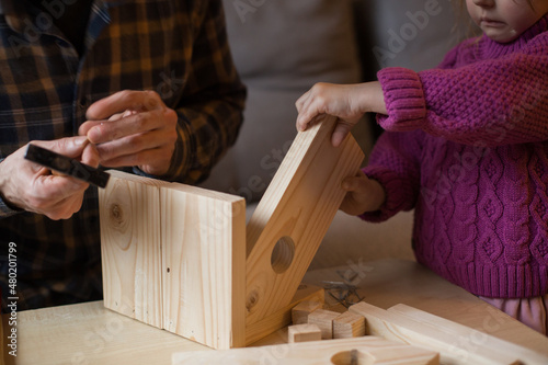 Making a wooden bird feeder. Dad and daughter are doing together. The concept of spending time together. Bird care