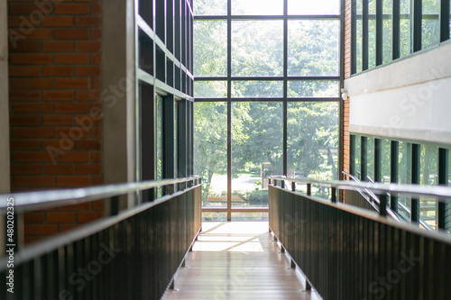 wooden slope walkway in the library with the window light from outside.