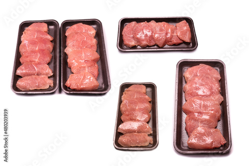 Turkey fillet in a black plastic container isolated.