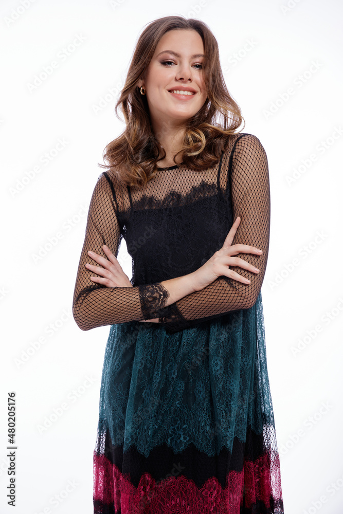 High fashion photo of a beautiful elegant young woman in a pretty triple black, red, green color dress with lace, blue shoes posing on white background. Slim figure, hair, shiny curls. Studio Shot