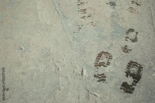 wet bootprints on dirty concrete floor photo