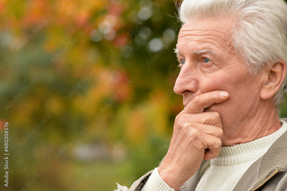 portrait of sad senior man in park portrait of sad senior man in park