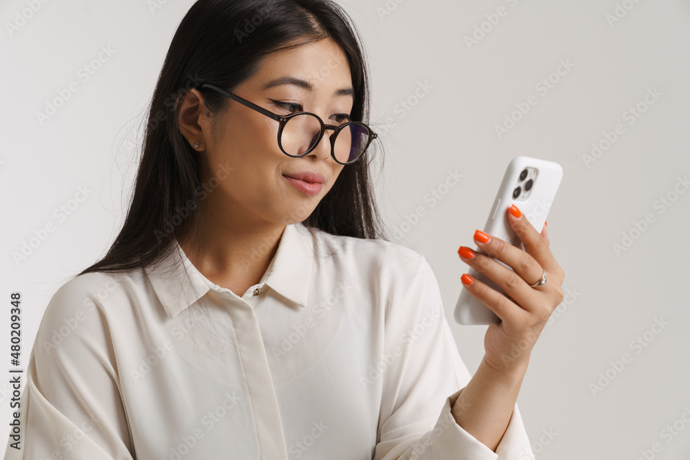 Young asian woman smiling and using mobile phone Young asian woman smiling and using mobile phone