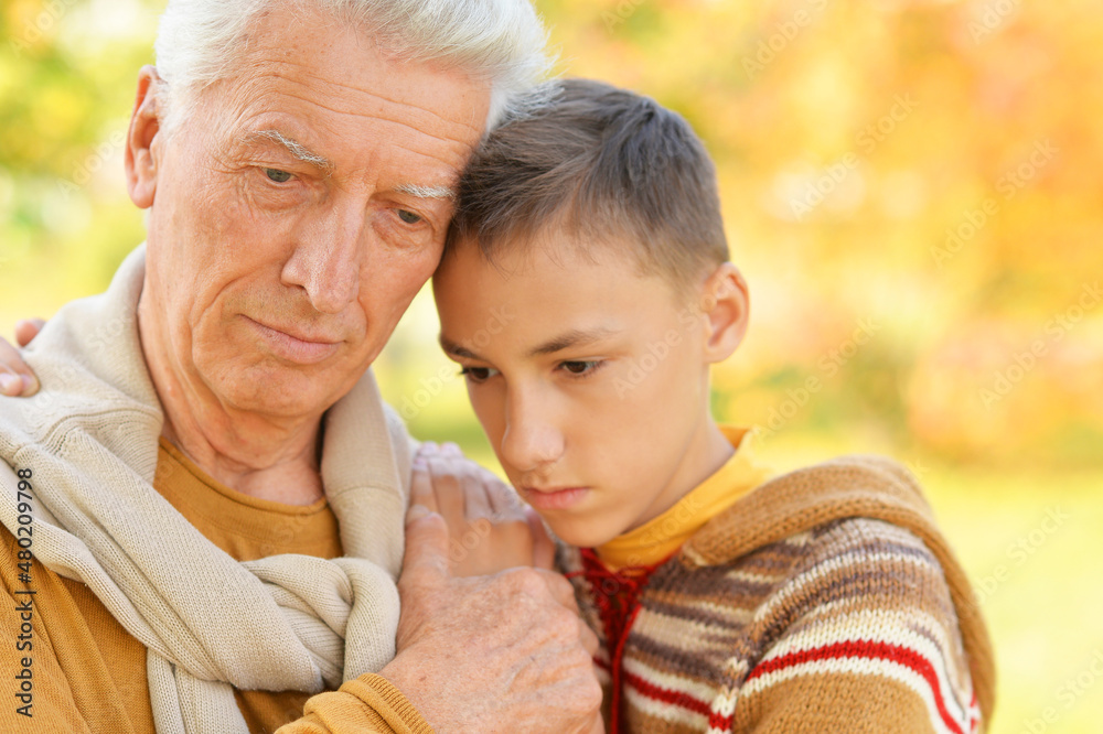 Portrait of sad grandfather and grandson hugging Portrait of sad grandfather and grandson hugging