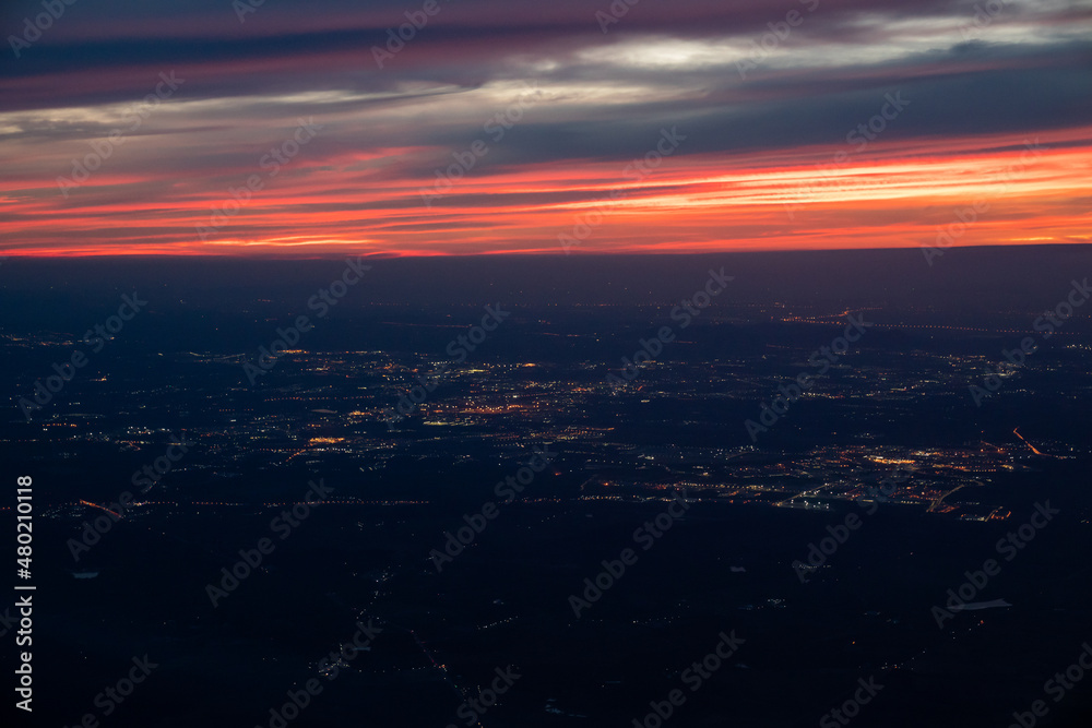 Twilight to Night from the jet plane view red orange blue sky with the light of Thailand city below