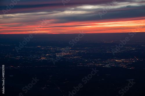 Twilight to Night from the jet plane view red orange blue sky with the light of Thailand city below