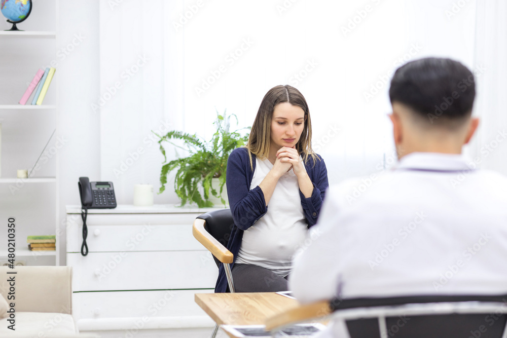 Photo of pregnant woman speaking with a doctor. Photo of pregnant woman speaking with a doctor.