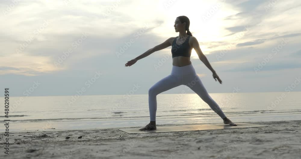 Young woman doing yoga at the beach. She practice yoga in beautiful beach sky. Healthcare and Exercise concept. Young woman doing yoga at the beach. She practice yoga in beautiful beach sky. Healthcare and Exercise concept.