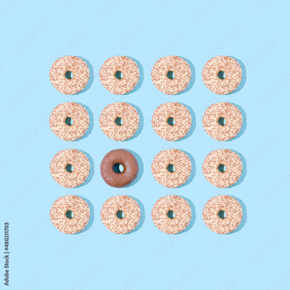 Doughnut pattern on pastel blue background. Chocolate donuts pattern. Brown colour mood. Unhealty and tasty meal. Beach mood. Flat lay. White chocolate domination. Doughnut pattern on pastel blue background. Chocolate donuts pattern. Brown colour mood. Unhealty and tasty meal. Beach mood. Flat lay. White chocolate domination.