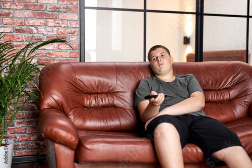 Foto caucasian teenager boy laid on sofa watching tv