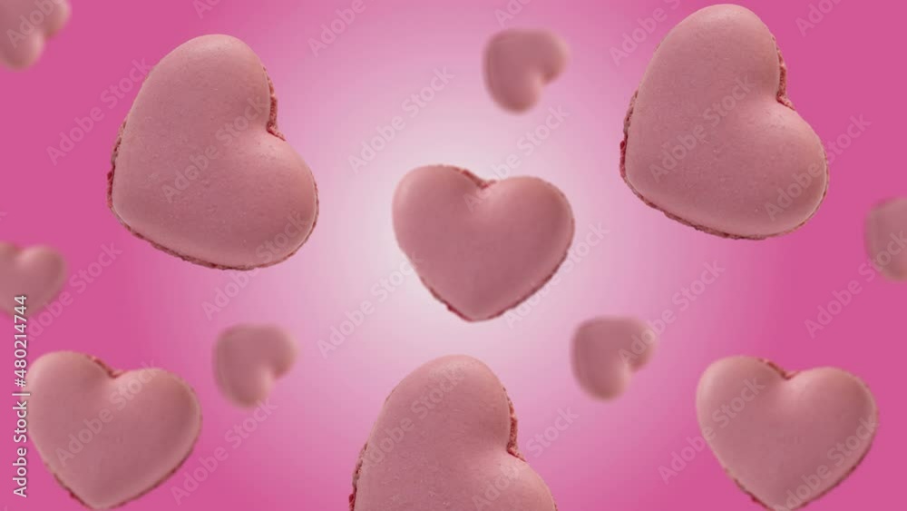 Flying and wiggle of different diameters many heart shaped French macaroons cookie on trending color pink gradient background. Romantic Love concept for mother's, St. Valentine's and women's day Flying and wiggle of different diameters many heart shaped French macaroons cookie on trending color pink gradient background. Romantic Love concept for mother's, St. Valentine's and women's day