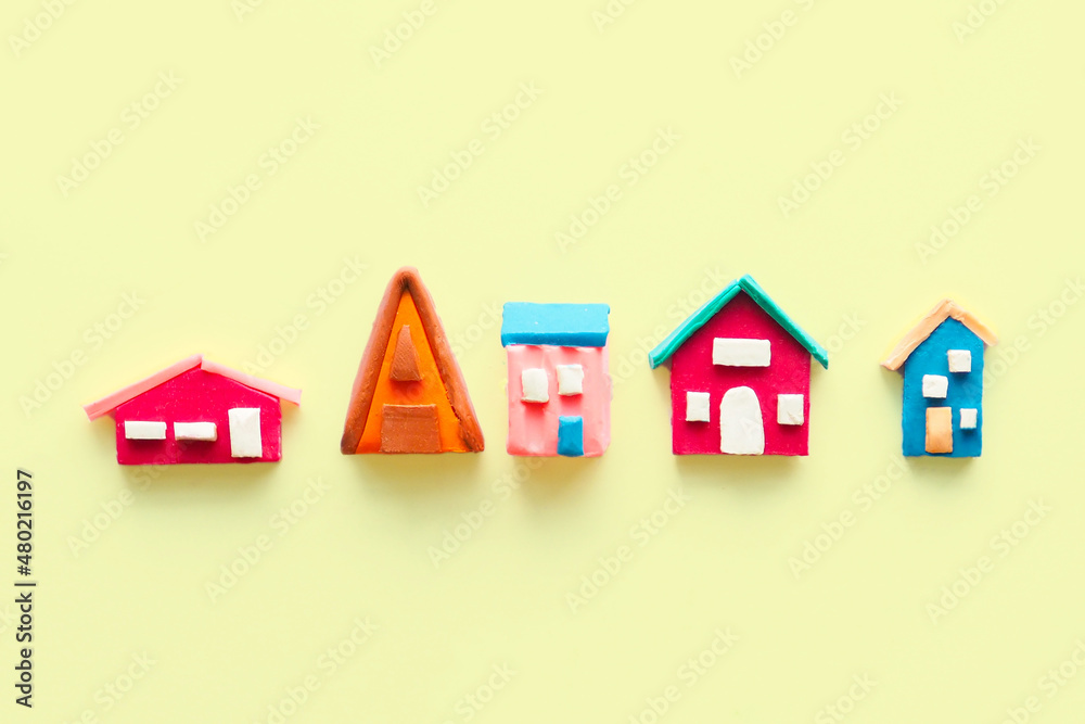 rustic multi-colored cute houses and plasticine on a yellow background..