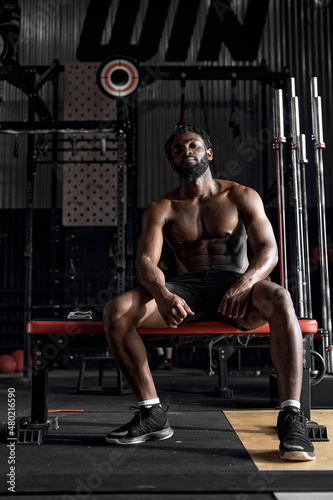 Dark-skinned African American Man Sit Having Rest, Relaxed After Intense Cross Fit Training In Gym, Healthy Lifestyle And Sport Concept. Fitness, Sport, Workout.