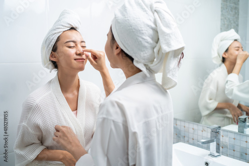 Asian lesbian gay couple putting smooth and skin care for facial soft. 