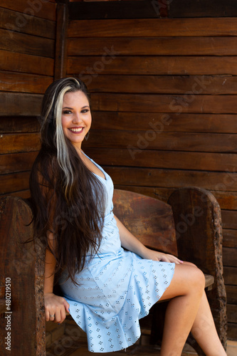 Mulher sorrindo sentada em banco de madeira