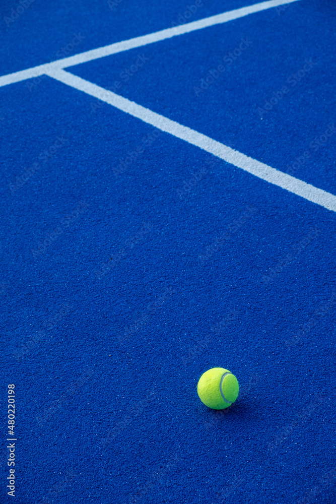 Paddle tennis ball on a blue paddle tennis court