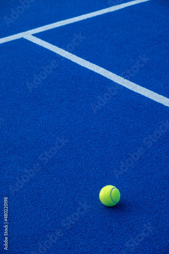 Paddle tennis ball on a blue paddle tennis court © Vic