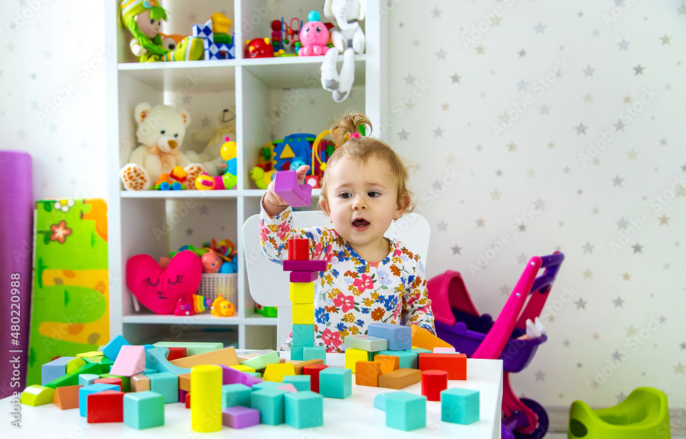 Fototapeta premium The child plays with toys in the room. Selective focus.