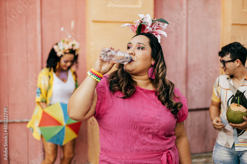 Brazilian Carnival. Person drinking water during carnival block on the street photo