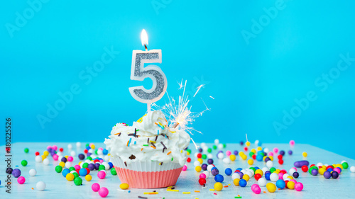 Beautiful congratulations on the birthday of a five-year-old child on a blue background, a card for 5 years happy birthday copy space. Festive background with cream cake