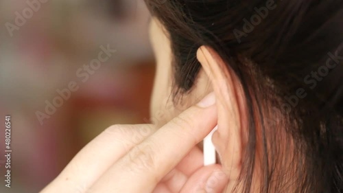 Close up of caucasian female with earphones in the ear and enjoying favourite music playlist listening application on cellular gadget and electronic earphones