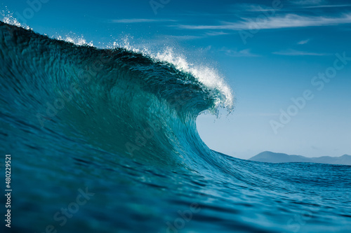 Ideal wave in Atlantic ocean. Blue glassy barrels and clear sky