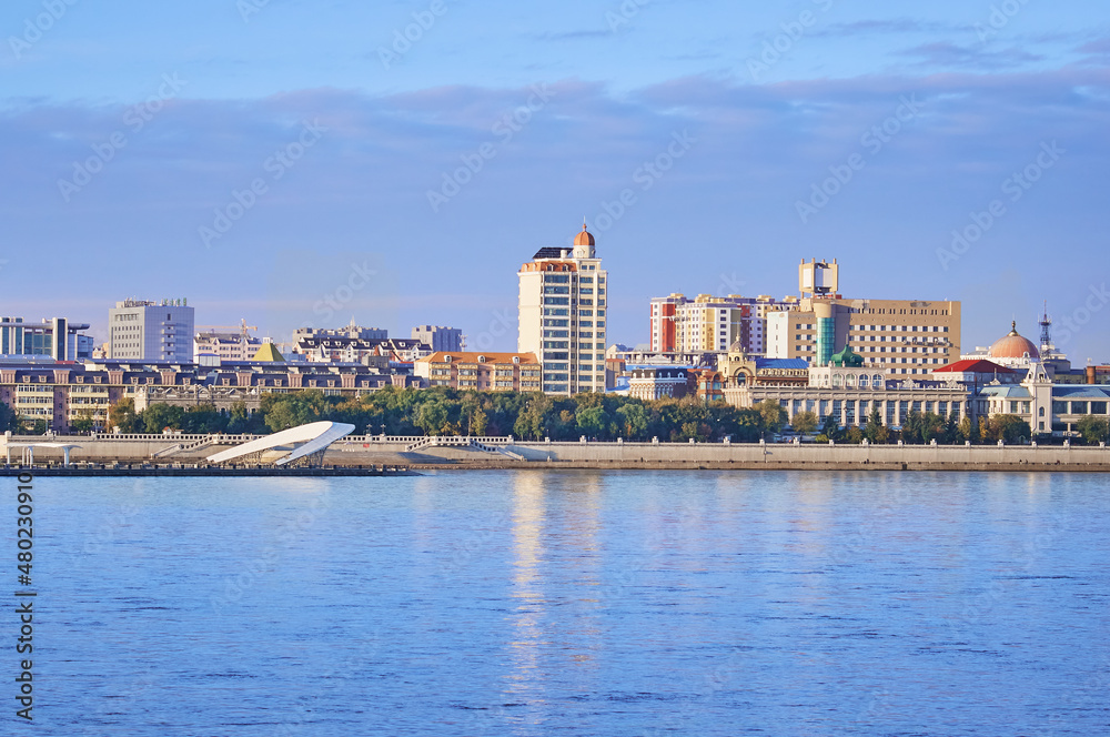 Russian-Chinese border along the Amur River. View from the embankment of the city of Blagoveshchensk, Russia to the city of Heihe, China. A mixture of architectural styles. The time of the golden hour