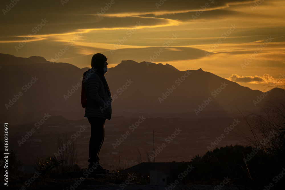 Silhouette of man on the mountain at sunset