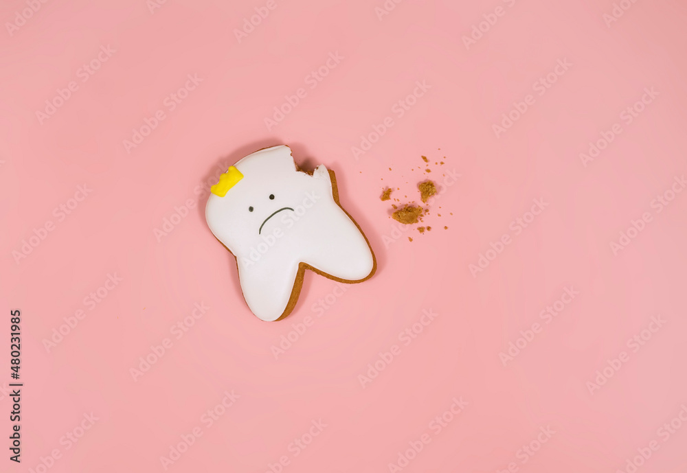 gingerbread in the shape of a tooth, background for the concept of pediatric dentistry and tooth fairy gingerbread in the shape of a tooth, background for the concept of pediatric dentistry and tooth fairy