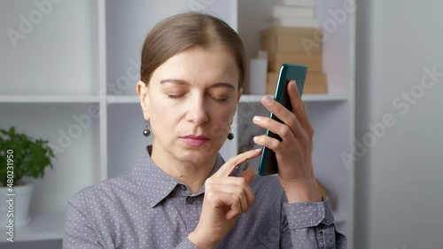 A blind woman listens to a mobile phone on voice communication.