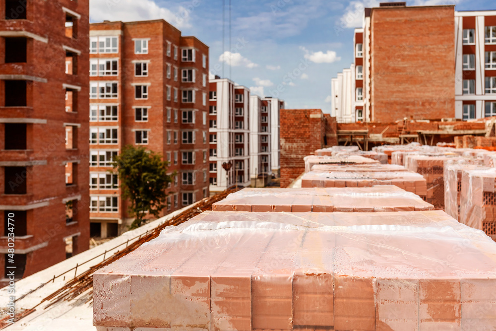 Fototapeta premium Construction Buildings. High-rise brick Houses under Construction. New Neighborhood of modern High-rise Buildings.