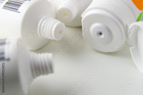 Dispensers of open tubes of cream close-up. White tubes with creams are open. Cope space. Screw-thread on the tuba close-up.