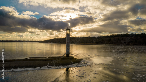 Aerial view of a pier with a lighthouse on a frozen lake