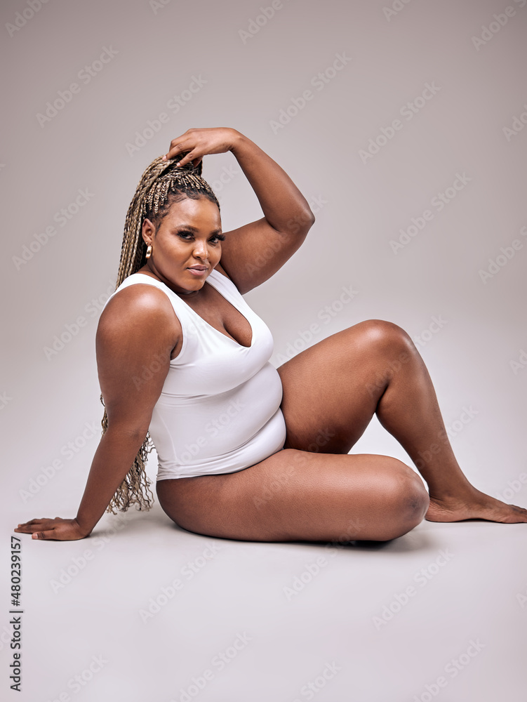 Self Acceptance, Love And Care. Portrait of smiling fat black woman with  perfect skin and body isolated in studio background, free copy space.  Gorgeous Lady with chubby body enjoy herself Stock Photo