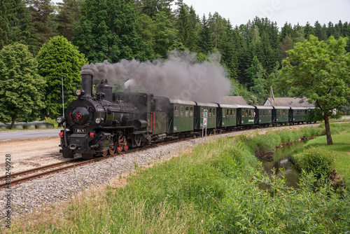 On a summer day a steam engine in Lower Austria steams along a stream. photo