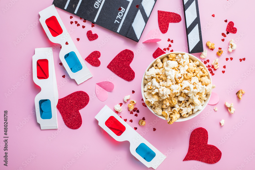 St. Valentine's day Movie night concept. Popcorn, 3d glasses clapper board on pink  background. Cozy holiday plans for lovers