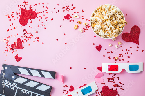 St. Valentine's day Movie night concept. Popcorn, 3d glasses clapper board on pink  background. Cozy holiday plans for lovers