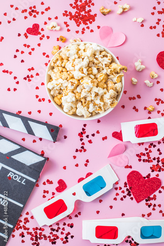 St. Valentine's day Movie night concept. Popcorn, 3d glasses clapper board on pink  background. Cozy holiday plans for lovers