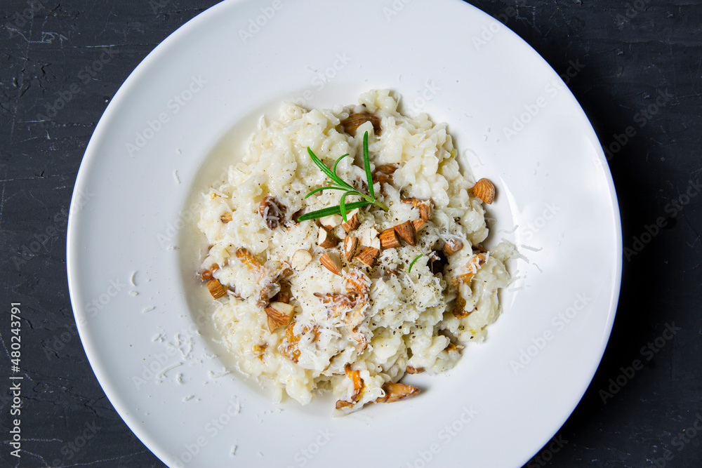 Tasty creamy risotto with mushrooms and almonds, top view. Traditional italian cuisine. Tasty creamy risotto with mushrooms and almonds, top view. Traditional italian cuisine.