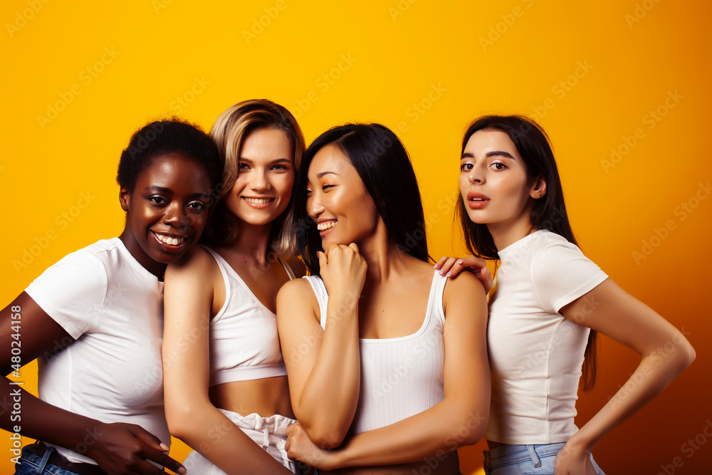 diverse multi nation girls group, teenage friends company cheerful having fun, happy smiling, cute posing on yellow background, lifestyle people concept, african-american, asian and caucasian diverse multi nation girls group, teenage friends company cheerful having fun, happy smiling, cute posing on yellow background, lifestyle people concept, african-american, asian and caucasian
