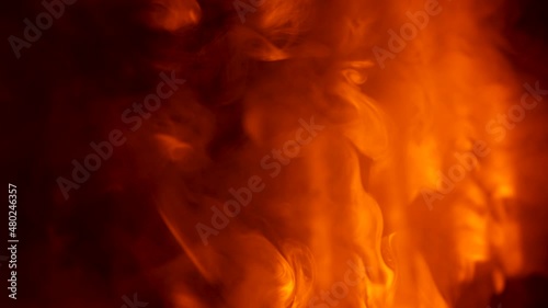 Cloud of smoke hovers and moves against background of dark empty studio in the rays of yellow red lighting stage lights. Colorful lighting effects on smoky dark nightclub stage. Close up. Slow motion. photo