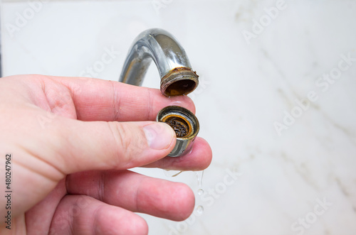 Dirty and clogged aerator from kitchen sink faucet. Plumbing work at home.