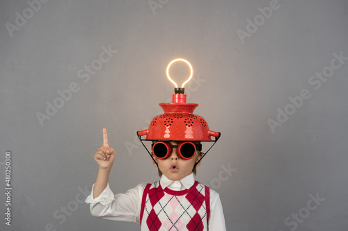 Smart child wearing funny helmet with illuminated lightbulb photo