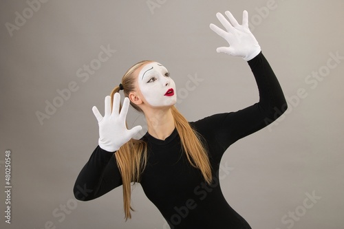 Obraz na płótnie Girl artist in the role of pantomime shows a touch on an invisible wall